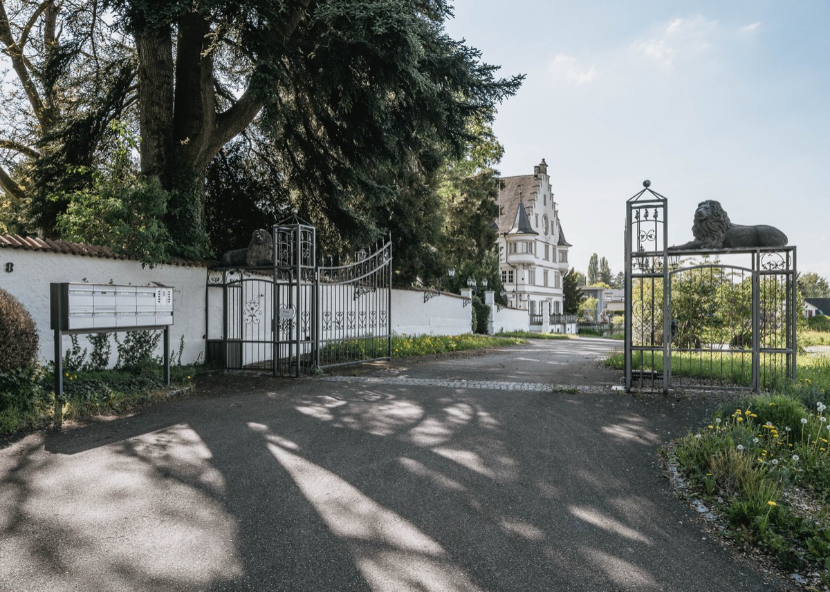 Schmiedeeisernes Tor mit steinernen Löwen am Eingang zum Schloss Römerburg