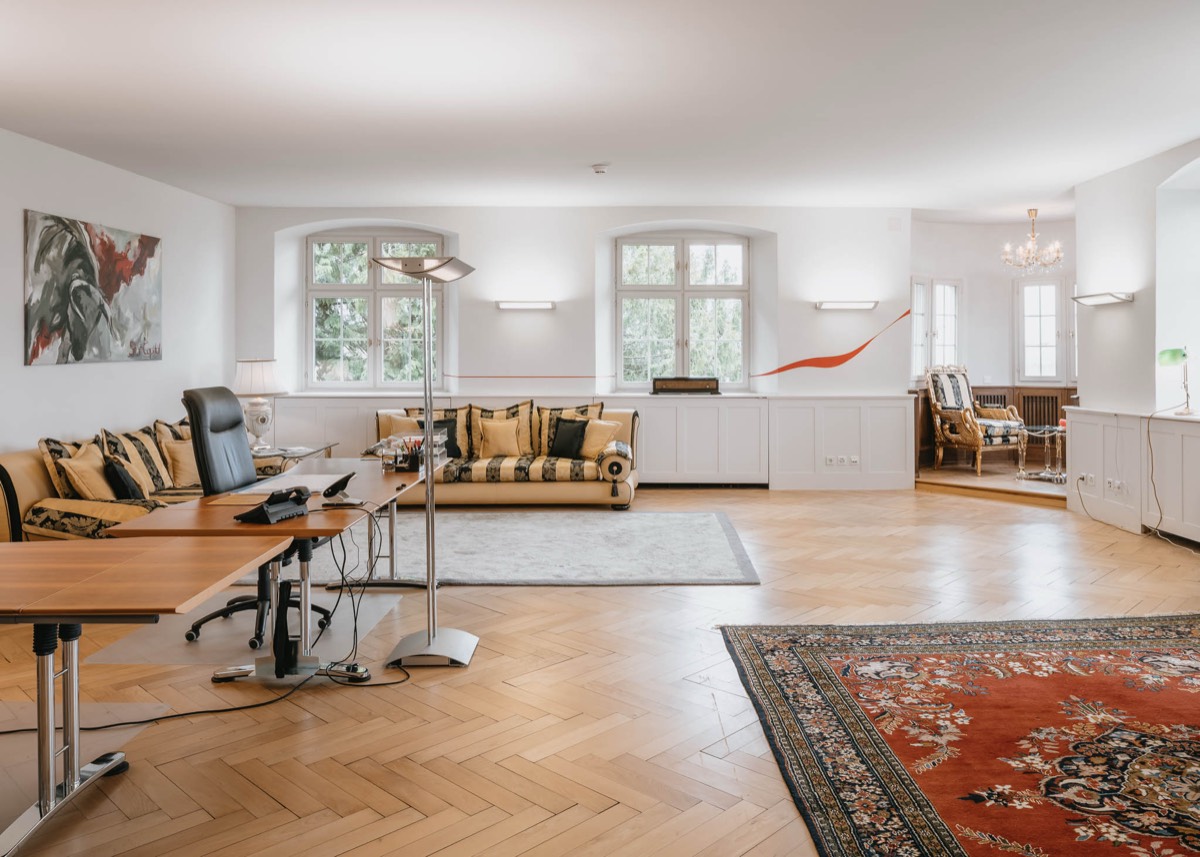 Direktionsbüro mit Schreibtisch, Sofas und Parkett